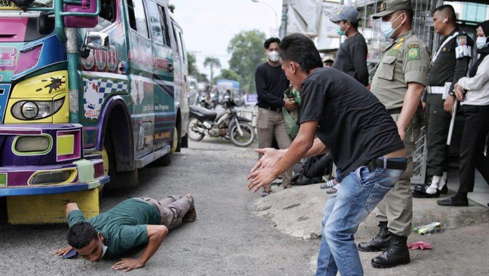 Sopir membawa penumpang di atap angkutan dihukum push up di posko penyekatan larangan mudik Lebaran, Jalan Jamin Ginting, Medan, Senin (17/5) (ANTARA/HO)