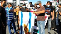 Aksi bakar bendera Israel dilakukan di Basra, Irak. Aksi itu untuk mengecam serangan Israel ke Gaza. AP/Nabil al-Jurani.