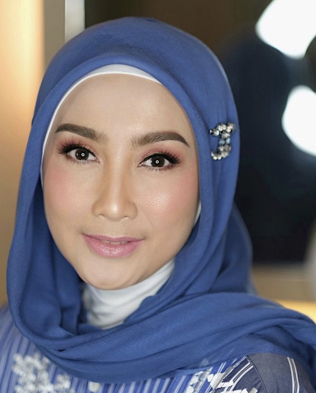 Selain hijab bahan paris, Desy Ratnasari juga memilih hijab segi empat bahan voal. Ia memadukan inner ninja putih dengan hijab warna biru. Dan memakai bros di atas telinga bagian kanan. Gaya hijab tanpa menggunakan jarum pentul ini cocok buat kamu yang ingin ke acara pernikahan. Foto: Dok. Instagram @vivithalib.