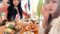 Sinb dan Umji juga tampak manis ketika menikmati makanan di kafe. Saat itu mereka menikmati tteokbokki, kentang goreng, dan aneka twigim. Foto: dok. GFRIEND SNS