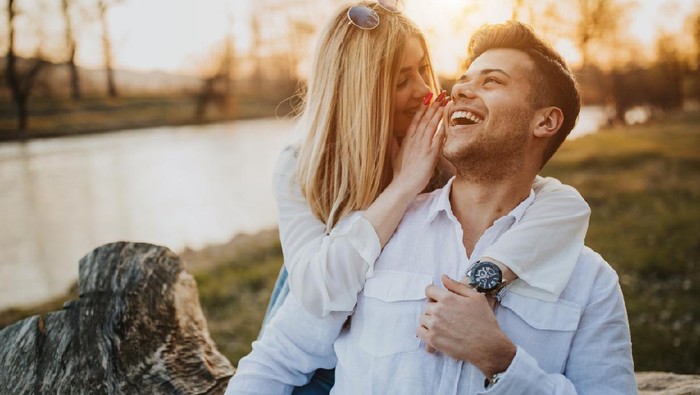 Happy young couple embracing by the river