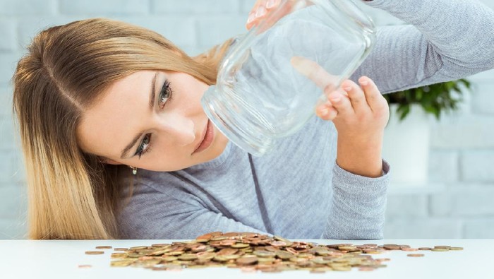 Beautiful woman with money jar. Bankruptcy concept.