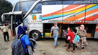 Sejumlah penumpang memasukan barang bawaan mereka ke bagasi salah satu bus yang ada di Terminal Pondok Pinang, Jakarta.