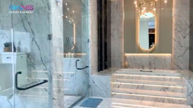 Kamar mandi utama di kamar Gilang yang bak hotel berbintang dengan lantai marmer dan bilik kaca.
