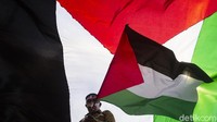 Bendera Palestina terus dikibarkan saat aksi di depan Kedubes Amerika Serikat ini.