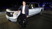 Ford F-150 Lightning modern, dengan bilah lampu tak terputus yang membentang dari lampu depan ke bawah. Jim Farley, chief executive officer Ford Motor Company, berdiri di samping Ford F-150 Lightning. AP Photo/Evan Vucci.