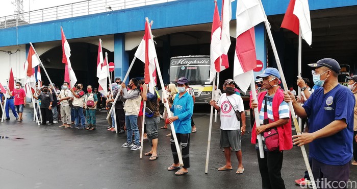 Karyawan, anggota komunitas serta pedagang di Terminal Tirtonadi, Solo, Jawa Tengah (Jateng) memperingati Hari Kebangkitan Nasional (Harkitnas), Kamis (20/5/2021). Peringatan diadakan tepak pukul 10.00 WIB ini dengan mengibarkan bendera merah putih dan menyanyikan lagu Indonesia Raya.