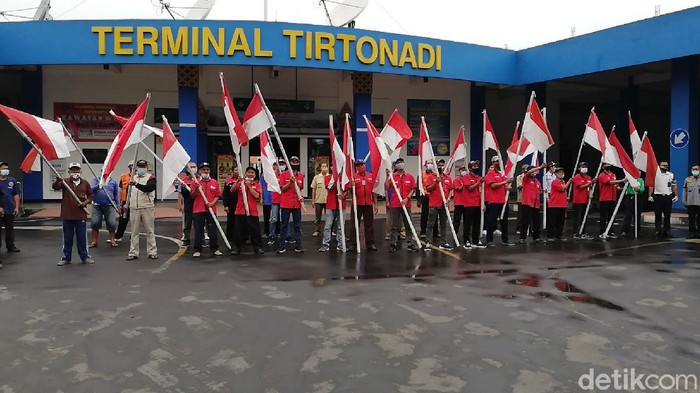 Karyawan, anggota komunitas serta pedagang di Terminal Tirtonadi, Solo, Jawa Tengah (Jateng) memperingati Hari Kebangkitan Nasional (Harkitnas), Kamis (20/5/2021). Peringatan diadakan tepak pukul 10.00 WIB ini dengan mengibarkan bendera merah putih dan menyanyikan lagu Indonesia Raya.
