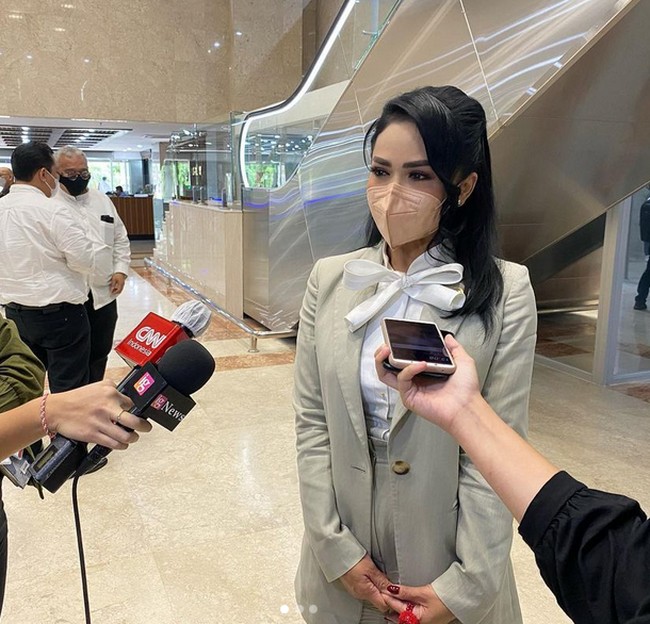 Krisdayanti tampil dengan kemeja dengan leher aksen pita. Tampilannya semakin formal dengan setelan blazer warna khaki. Penampilannya ini bisa jadi inspirasi baju kerja kamu juga, lho.  Foto: dok. Instagram/@krisdayantilemos