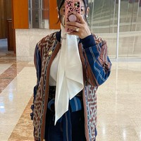 Kain tenun bisa dijadikan pakaian yang modern. KD menyulap kain tenun menjadi potongan jaket bomber. Agar tetap terlihat profesional, ia memadankannya dengan kemeja dengan aksen pita di bagian leher.  Foto: dok. Instagram/@krisdayantilemos