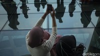 Sejumlah warga berfoto di area lantai kaca Pondok Indah Mall 3, Jakarta, Kamis (20/5/2021).   