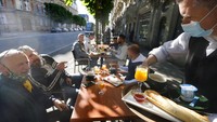 Warga Paris menikmati minuman di teras kafe di Paris, Rabu (19/5/2021) waktu setempat. Prancis telah melonggarkan lockdown karena COVID-19 mulai Rabu (19/5/2021). Restoran, museum, dan bioskop dibuka lagi. AP Photo/Jean-Francois Badias  