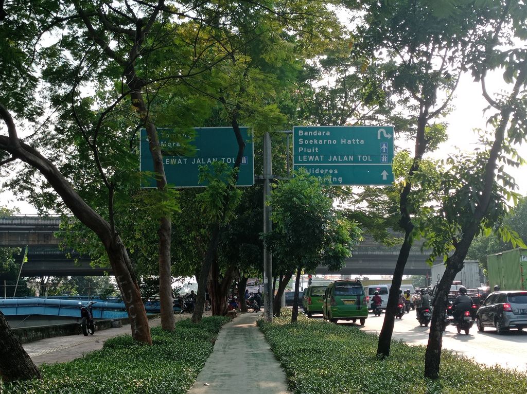 Penunjuk arah di Jl Daan Mogot, Jakarta Barat terhalang oleh pohon.