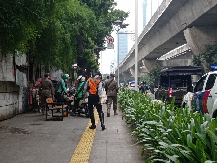 Petugas berjaga di Jl Prof Dr Satrio, Kuningan, Jakarta Selatan.