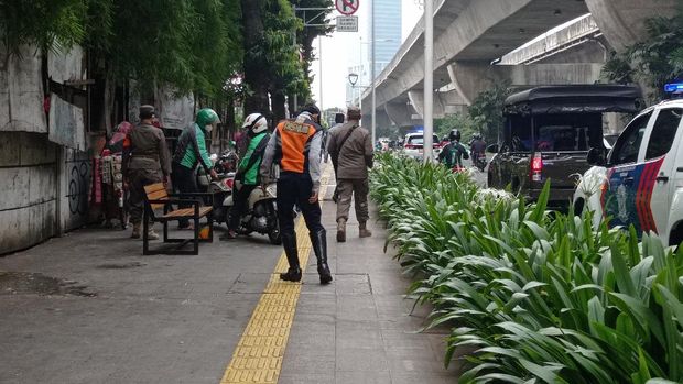 Petugas berjaga di Jl Prof Dr Satrio, Kuningan, Jakarta Selatan.