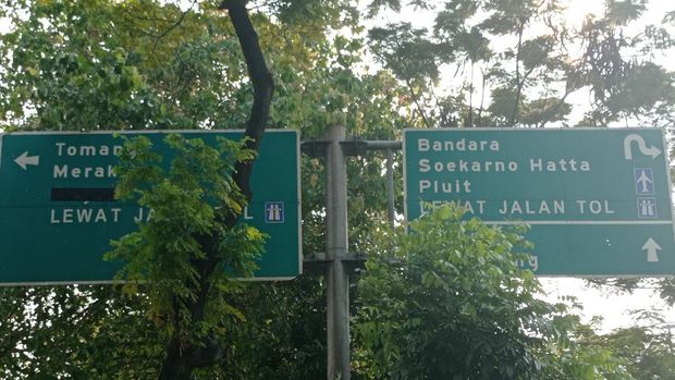 Petunjuk arah tol di Jalan Daan Mogot terhalang pohon dan berada di atas trotoar. Petunjuk arah tol di Jalan Daan Mogot terhalang pohon dan berada di atas trotoar.