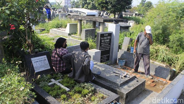 Seorang tukang tengah memperbaiki makam C.P Wolff Schoemaker