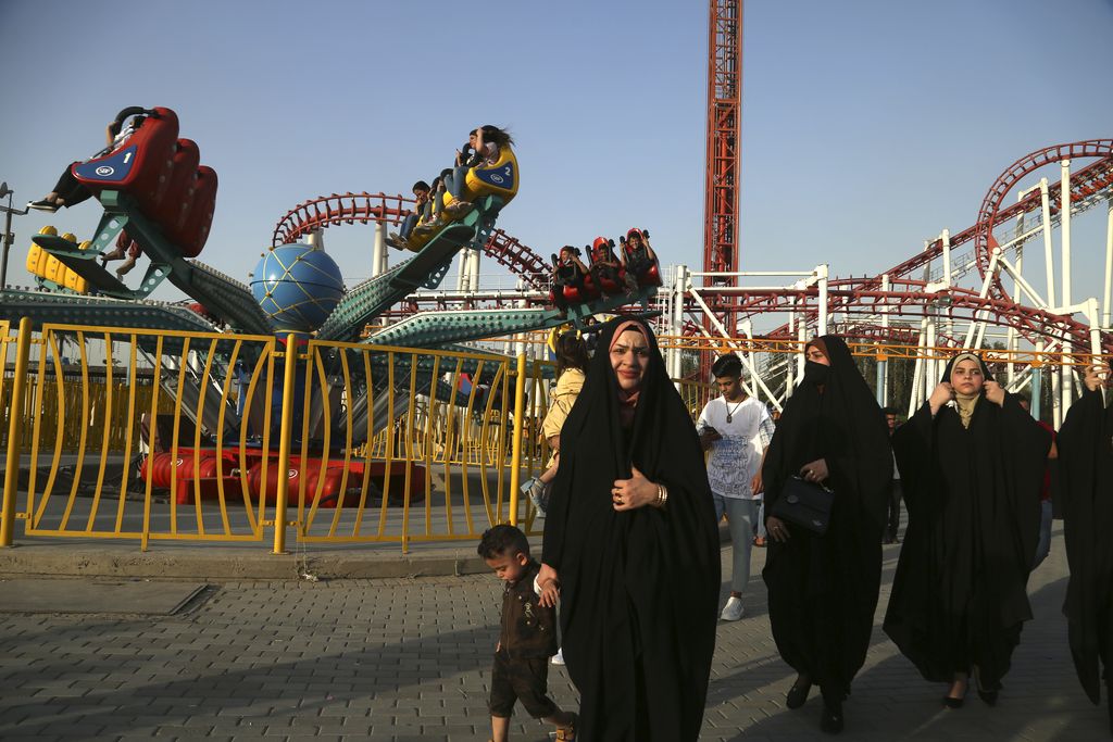 People enjoy a ride at an amusement park during Eid al- Fitr celebrations, that mark the end of the Muslim holy fasting month of Ramadan, in Baghdad, Iraq, Sunday, May 16, 2021. (AP Photo/ Hadi Mizban)