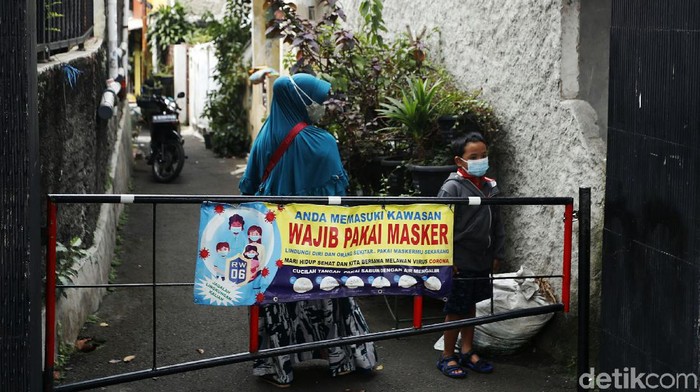 Spanduk Minta Pemudik Diswab Hiasi Kampung Makasar Jakarta Warga melintas didepan spanduk bertuliskan