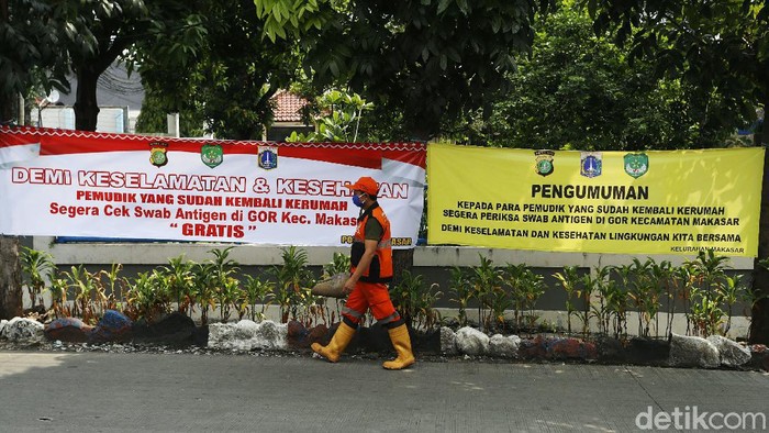 Warga melintas didepan spanduk bertuliskan 