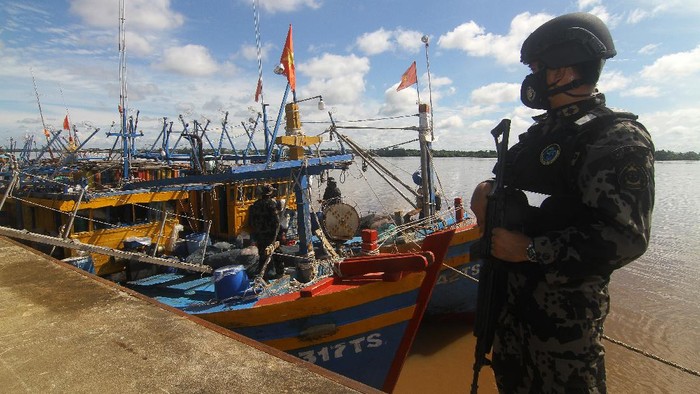 Sejumlah petugas berdiri di atas kapal ikan ilegal berbendera Vietnam di Dermaga Stasiun Pengawasan Sumber Daya Kelautan dan Perikanan (PSDKP) Pontianak di Kabupaten Kubu Raya, Kalimantan Barat, Kamis (20/5/2021). Dalam Operasi Lebaran yang dilaksanakan pada liburan Idul Fitri 2021, Kapal Pengawas Hiu Macan 01 Kementerian Kelautan dan Perikanan (KKP) yang dinahkodai Kapten Samson menangkap enam kapal ikan asing berbendera Vietnam beserta 36 Anak Buah Kapal (ABK) saat sedang menjaring cumi-cumi secara ilegal di Laut Natuna Utara pada Minggu (16/5/2021). ANTARA FOTO/Jessica Helena Wuysang/foc.