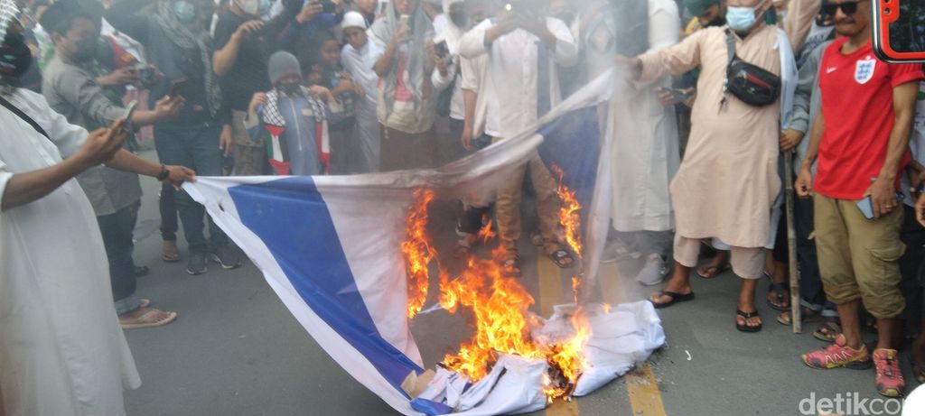 Aksi bela Palestina di depan DPRD Sulteng diwarnai pembakaran bendera Israel. Massa juga membawa bendera Palestina berukuran raksasa. (M Qadri/detikcom)