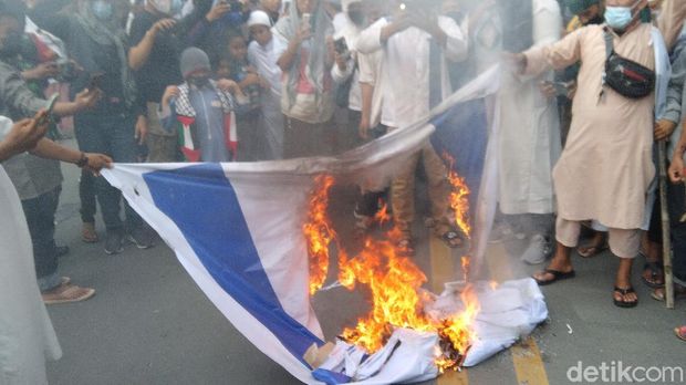 Aksi bela Palestina di depan DPRD Sulteng diwarnai pembakaran bendera Israel. Massa juga membawa bendera Palestina berukuran raksasa. (M Qadri/detikcom)
