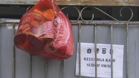 Paket bahan pokok diletakkan di pagar rumah warga yang menjalani isolasi mandiri di Jalan As-Syafiiyah, Cipayung, Jakarta, Jumat (21/5/2021).