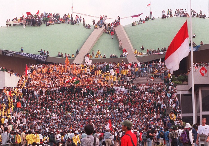 Indonesian students climb on the roof of the assembly hall of parliament 19 May in Jakarta during a demonstration.  Thousands of students gathered at parliament, pressing for reforms and vowing to keep fighting until Suharto steps down.  The students cheered at the announcement Suharto made on national television, saying that he would not seek another term as president and promising new parliamentary elections soon.  AFP PHOTO/CHOO Youn-Kong (Photo by CHOO YOUN-KONG / AFP)