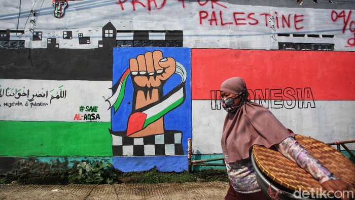 Mural Dukungan Untuk Palestina Mejeng di Depok Warga melintas di depan mural yang menggambarkan Solidaritas untuk Palestina di Sawangan, Depok, Jawa Barat, Jumat (21/5/2021).