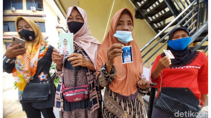 Orang tua menunjukkan foto keempat gadis asal Palembang yang hilang bersamaan (Prima S/detikcom)