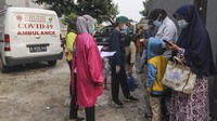 Petugas medis mendata warga yang akan dibawa ke Wisma Atlet di Jalan As-Syafiiyah, Cipayung, Jakarta, Jumat (21/5/2021).