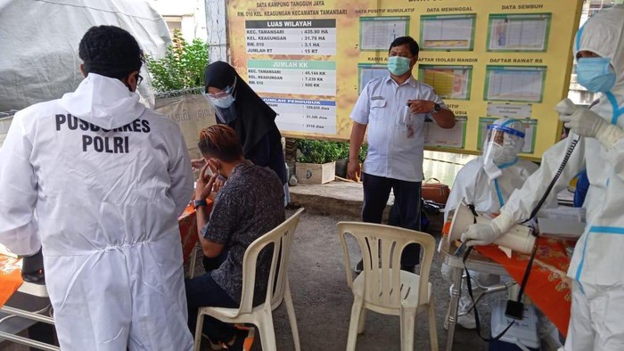 Petugas menyemprot disinfektan di wilayah rumah warga yang positif COVID-19 usai mudik