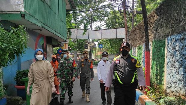 Petugas menyemprot disinfektan di wilayah rumah warga yang positif COVID-19 usai mudik
