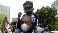 Massa aksi tersebut tampak membawa berbagai atribut, mulai dari ikat kepala hingga bendera Merah Putih.  