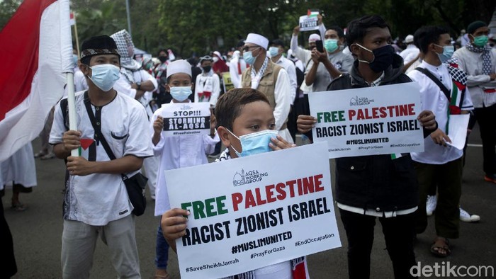 Potret Anak-anak di Tengah Aksi Bela Palestina Depan Kedubes AS Sejumlah massa kembali gelar aksi bela Palestina di depan Kedubes AS, Jakarta. Di antara kerumunan massa, terlihat sejumlah anak ikut serta dalam aksi tersebut.