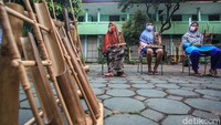 Satu per satu instruktur dan guru kesenian melatih para lansia bermain angklung.