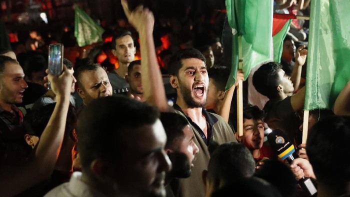 Palestinians wave green Hamas flags while celebrating the cease-fire agreement between Israel and Hamas in Gaza City, early Friday, May 21, 2021. (AP Photo/Adel Hana)
