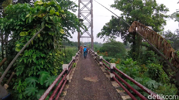Pesepeda melewati jembatan gantung di Curug, Depok. Jembatan ini menghubungkan Depok dan Bogor