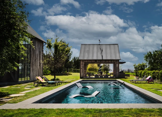 Halaman dilengkapi kolam renang dan patio bergaya lumbung juga sebagai area entertainment. (Foto: Dok. Architectural Digest/Douglas Friedman)