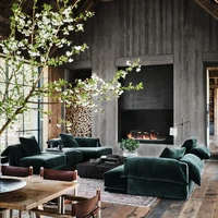 Kayu-kayuan berwarna hitam mendominasi interior rumah. Di ruang keluarga yang dilengkapi perapian, terdapat sebuah sofa lounge hijau berbahan beludu yang mempertegas aura kemewahan rumah tersebut. Foto: Dok. Architectural Digest/Douglas Friedman