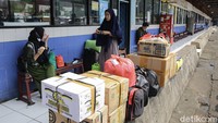 Para pemudik yang membawa barang bawaan khas mudik seperti tas besar, kardus hingga koper sedang menunggu kedatangan bus yang akan ditumpanginya.