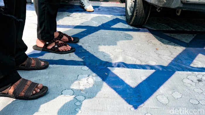 Sejumlah massa gelar aksi bela Palestina di Tangerang Selatan. Di tengah pelaksanaan aksi, massa tampak menginjak bendera Israel. Berikut penampakannya.