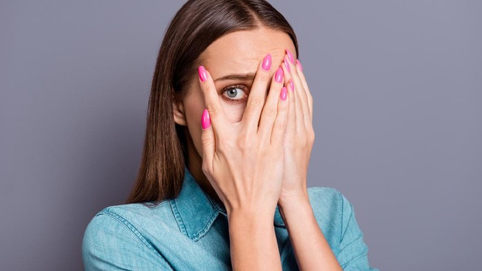 Close up studio photo portrait of sad upset unhappy afraid scared with brown hairstyle cute shy lady people person closing face with palms isolated on gray background