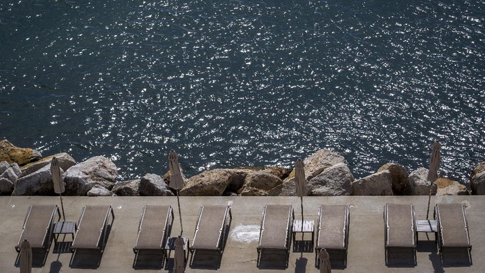 A couple sits at the seafront in Opatija, Croatia, Saturday, May 15, 2021. Croatia has opened its stunning Adriatic coastline for foreign tourists after a year of depressing coronavirus lockdowns and restrictions. (AP Photo/Darko Bandic)