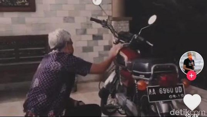 Ganjar Pranowo mengelap sepeda motor merahnya. (TikTok @ganjarpranowofc)