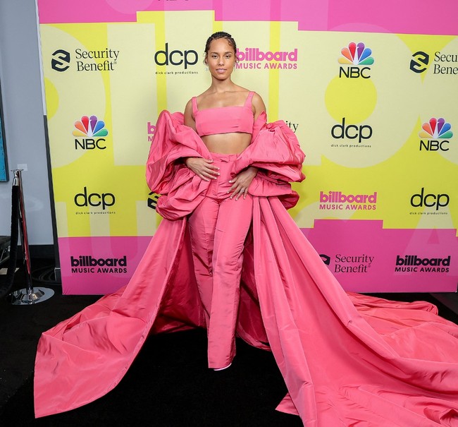 Alicia Keys dikenal senang berbusana nyentrik. Termasuk gaya yang diperlihatkannya saat berpose di red carpet Billboard Music Awards 2021, Minggu (23/5/2021) malam. Penyanyi soul R&B ini mengenakan setelan crop top dan celana high-waist warna fushchia yang dipadukan jubah beraksen dramatis rancangan Valentino. Foto: Rich Fury / GETTY IMAGES NORTH AMERICA / Getty Images via AFP