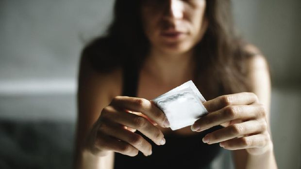 Woman holding package of condom on her hands