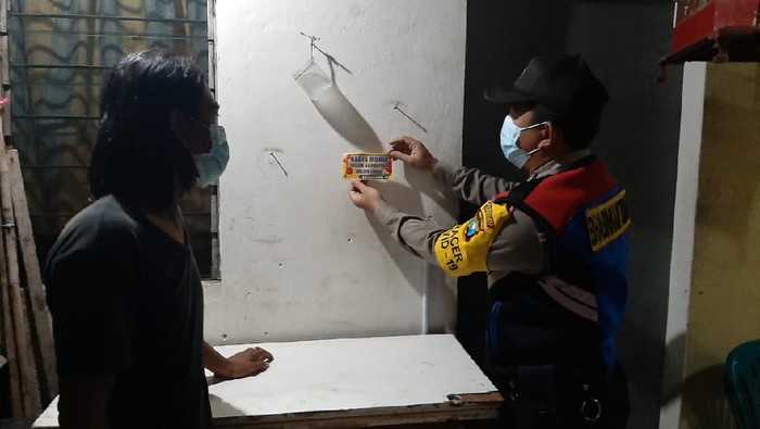 Polisi Surabaya melakukan sosialisasi untuk mencegah penyebaran COVID-19. Polisi menempelkan stiker imbauan di rumah warga yang habis mudik, agar melakukan karantina dan tes swab.