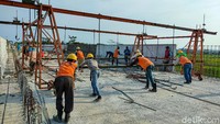 Para pekerja tampak sibuk mengerjakan pembangunan jalur KA bandara YIA.
